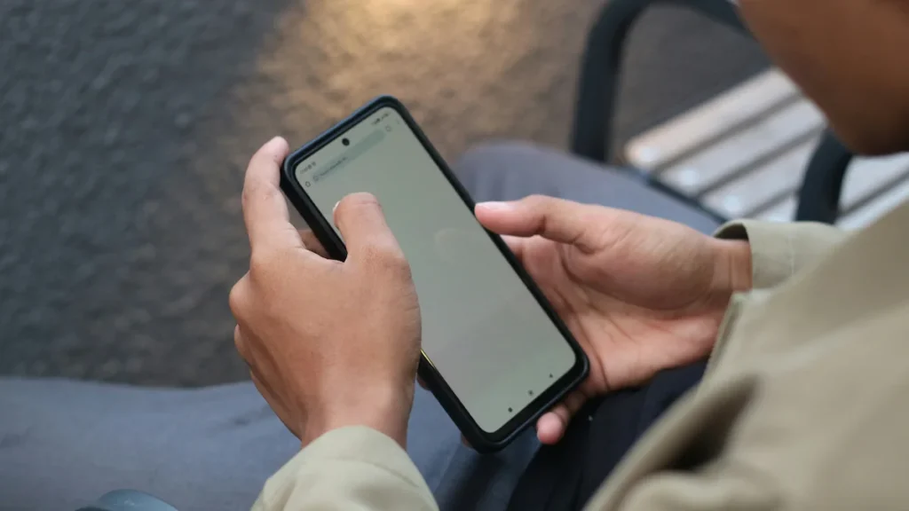 Persona sosteniendo un smartphone, consultando información en la calle - Colmena X